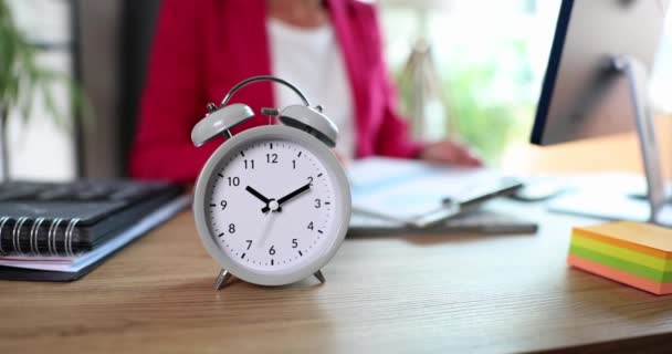 Reloj despertador a las diez en punto en la mujer de negocios analista de marketing trabaja con documentos en la oficina. Control remoto del tiempo de trabajo - Metraje, vídeo