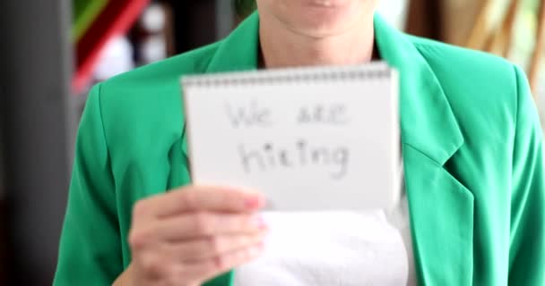 La donna tiene la carta in mano con l'iscrizione che stiamo assumendo. Ricerca di lavoro curriculum di successo e concetto di business - Filmati, video