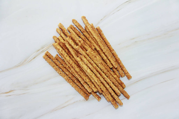baked dry long bread sesame sticks on a marble background - Photo, Image