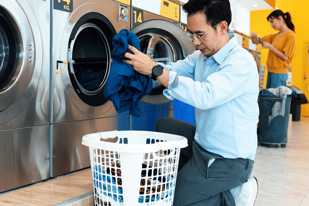 Asian people using qualified coin operated laundry machine in the public room to wash their cloths. Concept of a self service commercial laundry and drying machine in a public room. - Foto, Imagem
