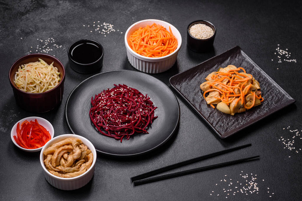 Chutná kořeněná korejská řepa s kořením a bylinkami na tmavém betonovém pozadí. Asijské jídlo - Fotografie, Obrázek