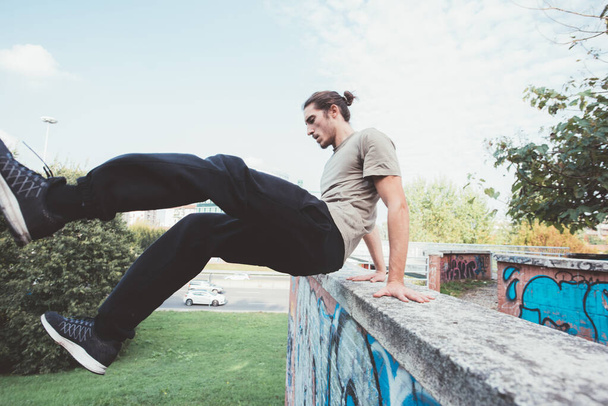 acrobático truco hombre al aire libre haciendo parkour entrenamiento truco - Foto, Imagen
