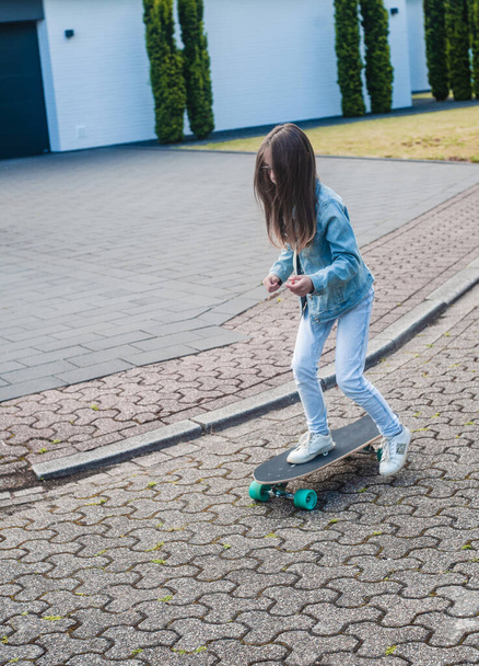 young girl with her skateboard on a sunny day in the park - Foto, afbeelding