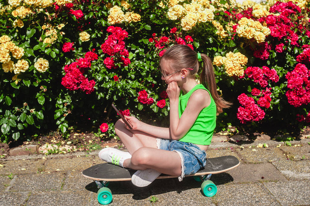 young girl with her skateboard on a sunny day in the park - Foto, imagen