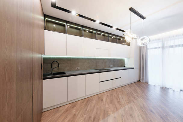 interior design of a large studio kitchen with light and dark facades - Foto, afbeelding