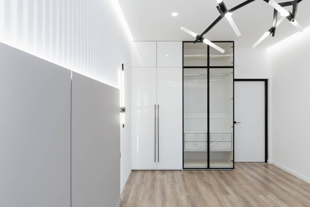 a large, spacious, bright room with a wardrobe and a mirror - Foto, immagini