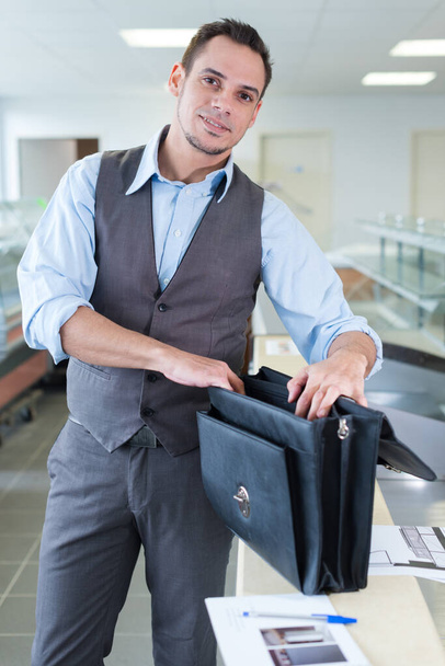 happy young businessman opening leather folder - Foto, Imagen