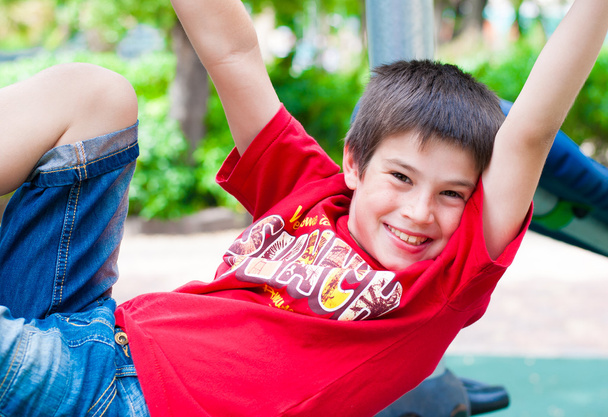 Jovem menino sorridente feliz brincando no parque
 - Foto, Imagem