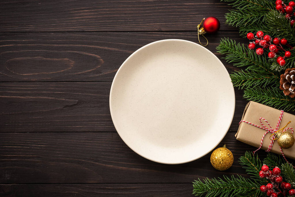 Comida navideña, cena navideña con plato artesanal y decoraciones navideñas sobre fondo de madera oscura. Vista superior con espacio de copia. - Foto, Imagen