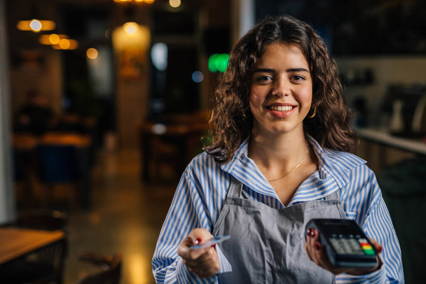 Front view of waitress charging a bill - Valokuva, kuva