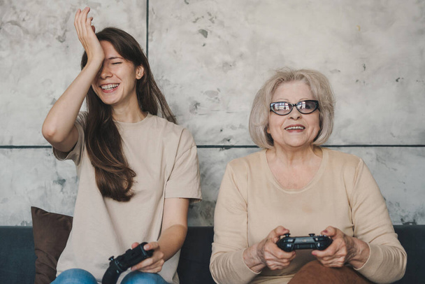Evde playstation oynarken zevk alan iki çılgın kadının portresi. Konsol oyun alanını ellerinde tutuyorlar. Ön manzara portresi. İnsanların yaşam tarzı. Bilgisayar - Fotoğraf, Görsel