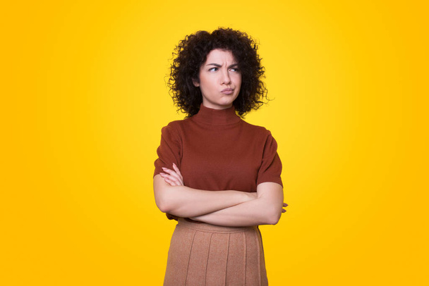 Portrait of young attractive woman concentrated about doubt, and looking up wondering. Isolated portrait. Yellow background. - Foto, afbeelding