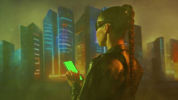 Portret dziewczyny cyberpunkowej. Piękna młoda kobieta na tle miejskich scyscraperów. Koncepcja futurystyczna. - Zdjęcie, obraz