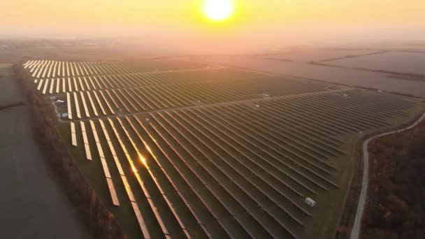 Luchtfoto van een grote duurzame elektriciteitscentrale met rijen fotovoltaïsche zonnepanelen voor het produceren van schone elektrische energie in de avond. Concept van hernieuwbare elektriciteit zonder uitstoot. - Video