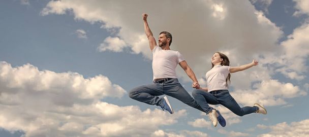 Father and daughter jump on sky, banner with copy space. happy father and daughter jump in sky. family day. - Fotó, kép