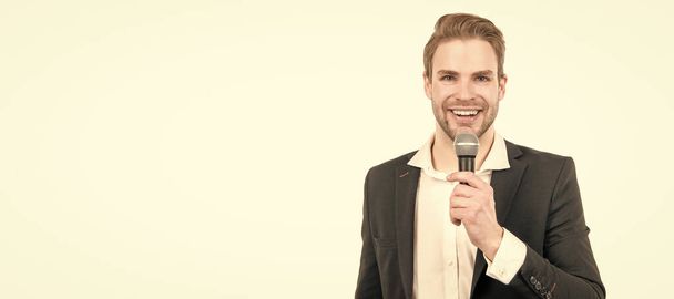 Happy man in business formalwear speak into microphone giving speech isolated on white, conferencier. Man face portrait, banner with copy space - 写真・画像
