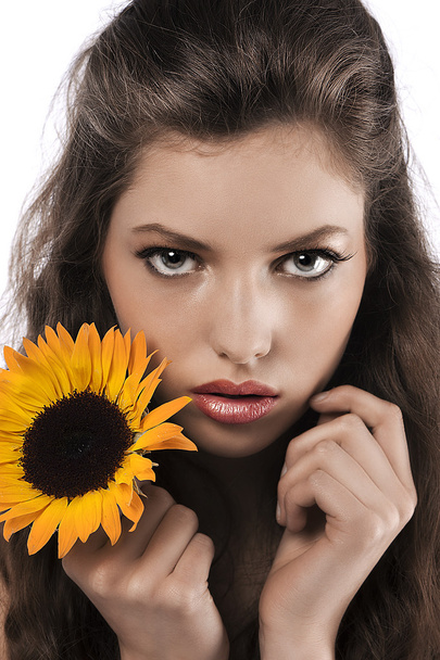 Face shot of a pretty girl holding a sunflower - Foto, Imagem