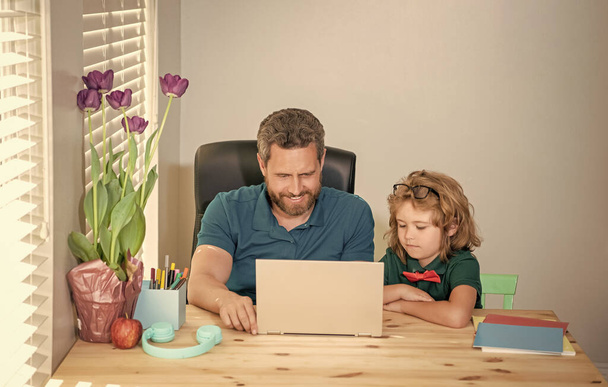 cheerful mature man teacher or dad helping kid son with school homework on computer, knowledge. - Photo, Image