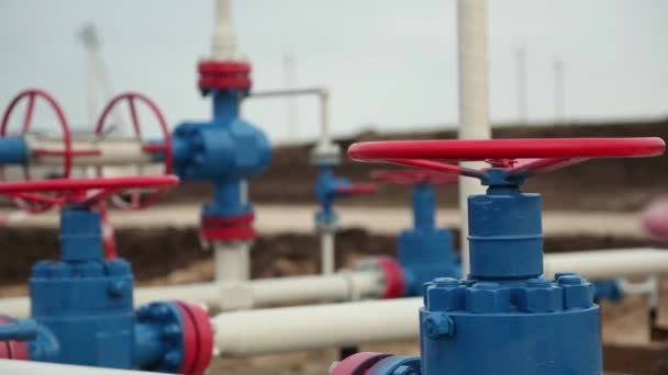 Sistema de transporte de petróleo, gas o químicos en una planta petroquímica. Grandes válvulas rojas y tubos azules - Metraje, vídeo