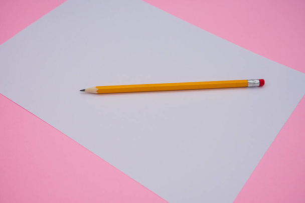 Blank white paper and yellow pencil on pink background. - Foto, Bild