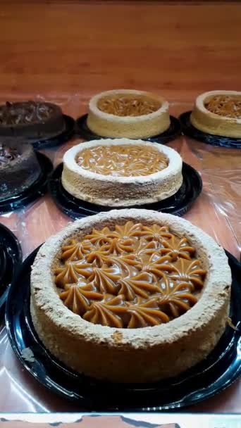 Wheat flour cake with dulce de leche frosting in a Brazilian bakery sowcase_vertical. - Footage, Video