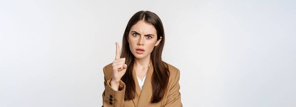Femme d'entreprise en colère, patron secouant désapprobation du doigt, gronder quelqu'un, interdire quelque chose, debout sur fond blanc. - Photo, image