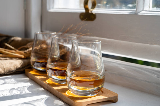 Flight of single malt and blended scotch whisky served on old wooden window sill in Scottisch house in Edinburgh, Scotland, UK, dram of whiskey - Valokuva, kuva