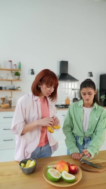 Junge Frauen schneiden Zitrusfrüchte, um in der Küche frischen Saft herzustellen - Filmmaterial, Video