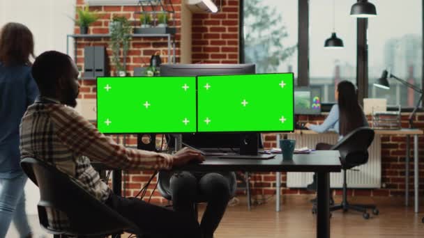 Trabajador de oficina mirando plantilla de pantalla verde en el ordenador, trabajando con pantalla de croma clave y maqueta aislada. Persona creativa que analiza el backgound del copyspace en blanco en las pantallas múltiples. - Imágenes, Vídeo