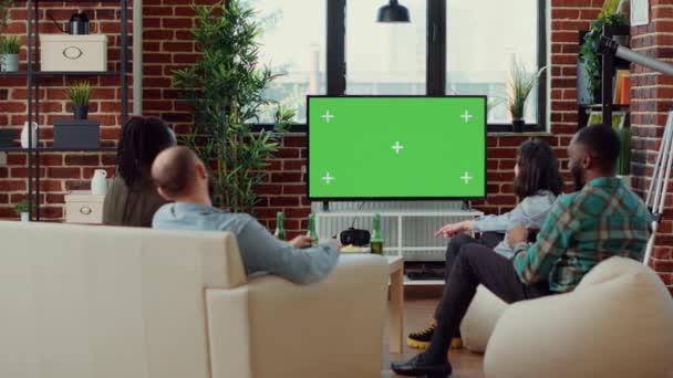Grupa osób korzystających z Greenscreen w telewizji do grania w gry wideo, patrząc na pusty szablon makiety. Gra online wyzwanie gry na pojedynczym tle klucza chroma, copyspace w telewizji. - Materiał filmowy, wideo