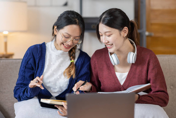 Young adult happy smiling Hispanic Two Asian student wearing headphones talking on online chat meeting using laptop in university campus or at virtual office. College female student learning remotely. - Fotoğraf, Görsel