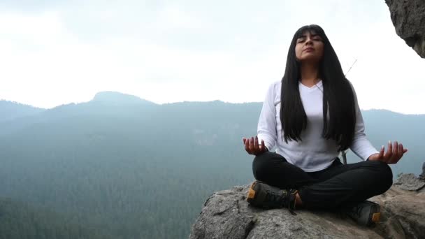 Jovem mulher meditando e respirando no topo de uma montanha e floresta - Filmagem, Vídeo