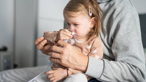 один ребенок с помощью туманности дома маленькая девочка ребенок с использованием пара ингалятора маска вдыхания в домашних медицинских процедур Лечение астмы пневмонии бронхит селективный фокус - Фото, изображение