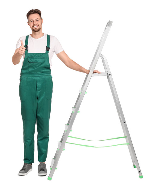 Worker in uniform near metal ladder on white background - Foto, afbeelding