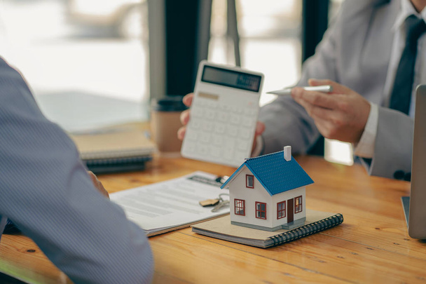 Das Konzept des Hauskaufs, bietet der Makler Zinskontrakte für Hypotheken und Immobilienkäufe für Kunden, um Verträge mit Immobilienmaklern zu unterzeichnen. - Foto, Bild