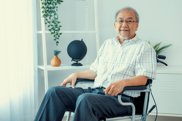 Portrait of a contented elderly man in sitting on a wheelchair at home. Senior person in nursing house service . - Zdjęcie, obraz