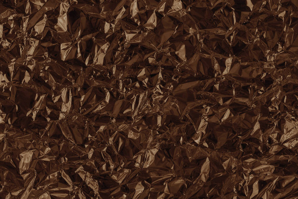 Shiny brown foil texture background, pattern of wrapping paper with crumpled and wavy. - Foto, Imagem