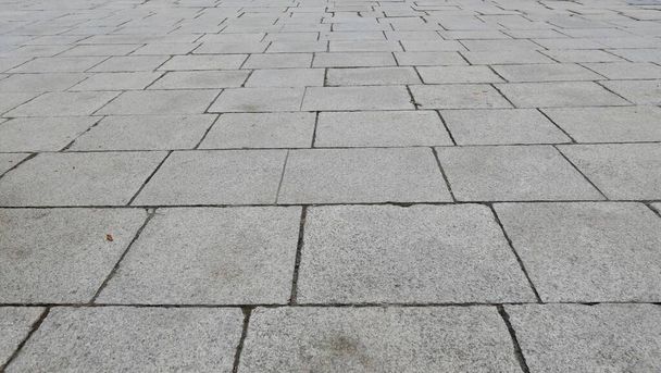 Full frame texture image of weathered grey paving stones leading into the distance. High quality photo - Photo, Image
