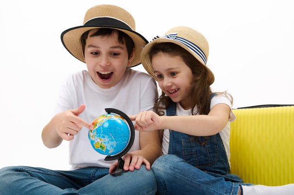 Iloisia ihastuttavia lapsia, poika ja tyttö keltainen matkalaukku, valitse paikka matkustaa ympäri maailmaa, valmis matkustamaan ulkomaille. Matkustaa. Matkaseikkailu konsepti. Lapset menossa kesälomalle - Valokuva, kuva