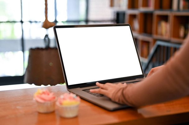 close-up immagine, Un telecomando femminile che lavora nella caffetteria, utilizzando computer portatile per gestire il suo lavoro online. Mockup schermo bianco portatile - Foto, immagini