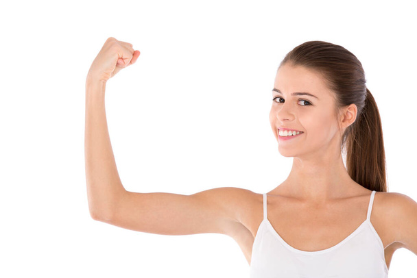 Working on those bulging biceps. Portrait of an attractive young woman pulling her muscle against a white background - Foto, immagini