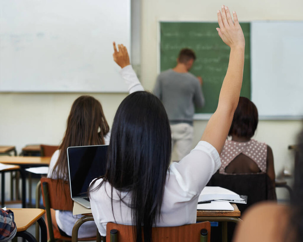I have a question...A female student raising her hand to ask a question during class - Foto, Imagen