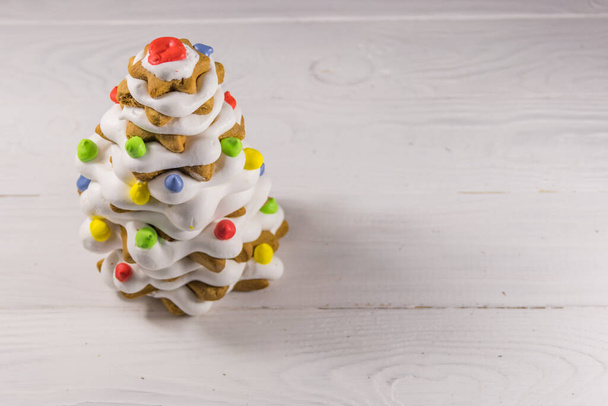 Gingerbread Christmas tree decorated with glaze on white wooden table - Photo, Image