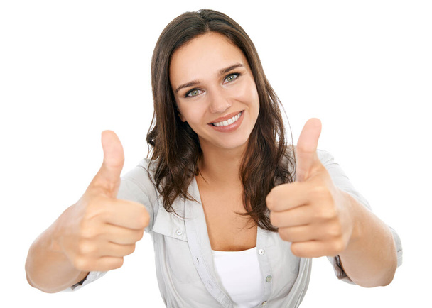 I whole-heartedly support you. Studio portrait of a young woman giving thumbs up to the camera isolated on white - Foto, Imagem