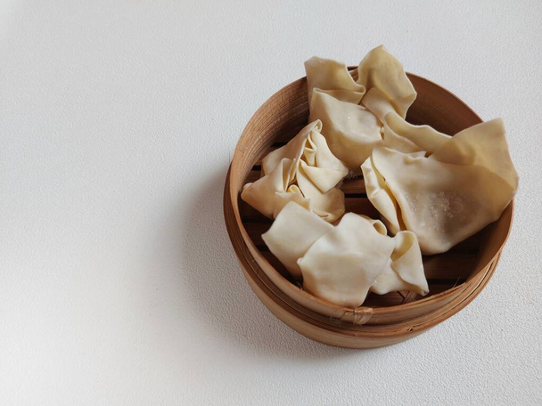 Bolinho cru ou dimsum em vapor de bambu. É comida tradicional da China. Sabor salgado. - Foto, Imagem