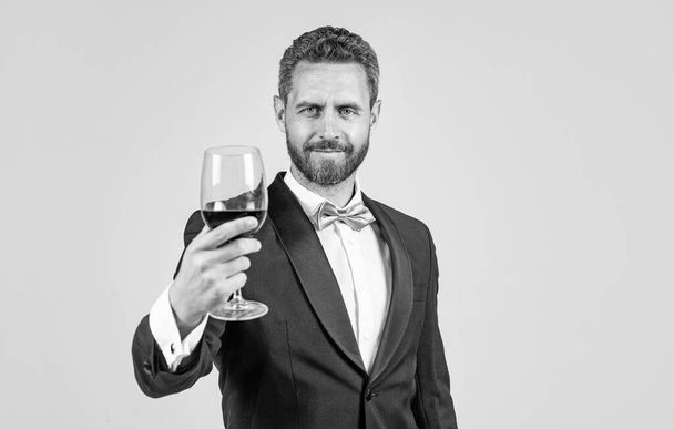 sommelier. guy drink red wine. cheers for valentines day. alcohol drinking. handsome male on romantic date. professional bartender on formal event. tuxedo man with wine glass. skilled barman. - Foto, Imagen