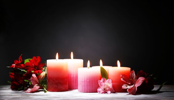 Beautiful candles with flowers on wooden table, on dark background - Фото, зображення
