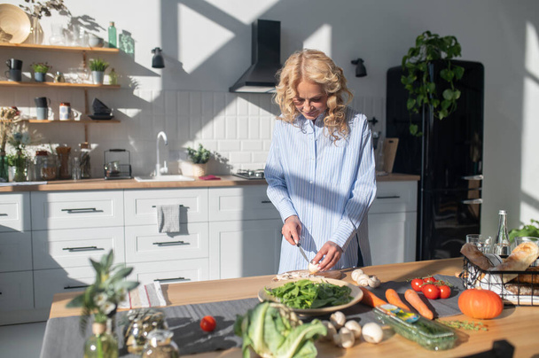 Preparing food. Blonde woman preparing food in the kitchen - Photo, Image