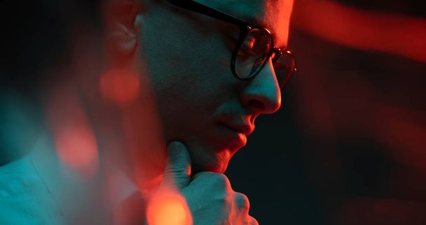 Cinematic night closeup portrait of handsome man neon lights. Concept of fashion, style, human emotions, facial expressions. Male fashion model wearing eyeglasses. - Valokuva, kuva