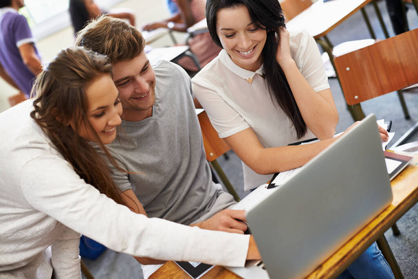 Nevetsz az órán. fiatal egyetemisták egy csoportja együtt dolgozik egy laptopon. - Fotó, kép